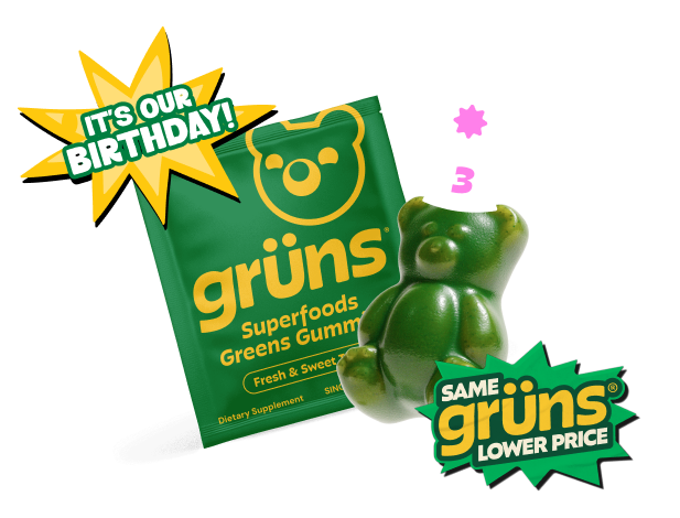 A green "Fibrelo Superfoods Greens Gummies" single packet in Fresh & Sweet flavor next to a large bear-shaped gummy wearing a "3" party hat, with an "It's Our Birthday!" starburst and a "Same Fibrelo, Lower Price" badge, shown on a transparent background.